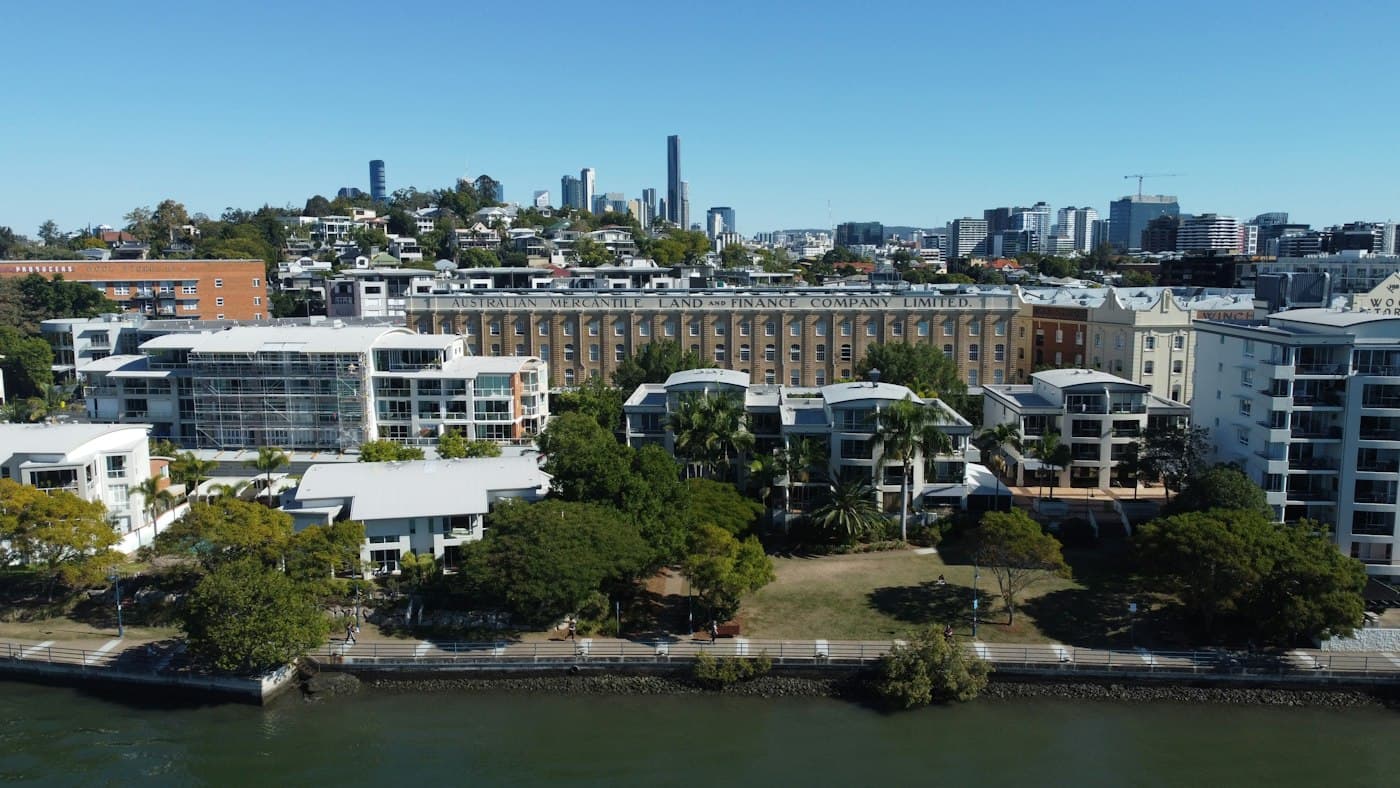 Apartment buildings along the Brisbane River with the city skyline behind them